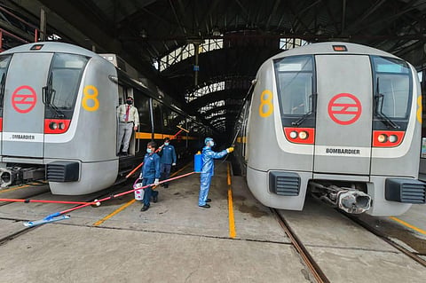 A worker sanitises a metro coach as Delhi Metro Rail Corporation DMRC resumes its services from today (Photo | PTI)