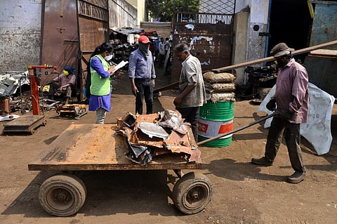 A corporation employee, on door-to-door survey, asking people of covid-19 symptoms at an auto-scrapyard at Pudupet in Chennai (Photo | EPS)