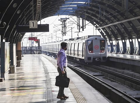 A commuter waits for a metro train at Rajouri Garden station following resumption of metro services on the Blue and Pink Line in a graded manner in New Delhi Wednesday. (Photo | PTI)