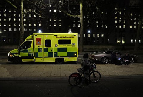 A woman with a bicycle walks past an ambulance and members of the media on the north bank of the River Thames opposite the London Eye ferris wheel by the River Thames in London. (Photo | AP)