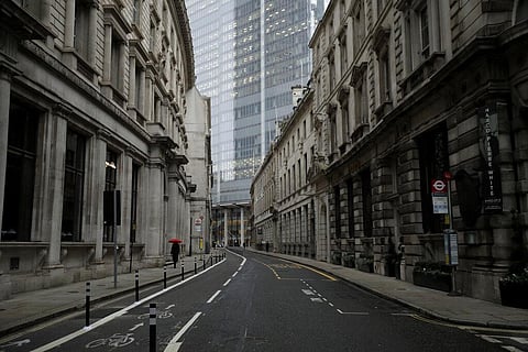 In this London, Jan. 5, 2021 file photo a person walks with an umbrella in light rain in the City of London financial district. (Photo | AP)