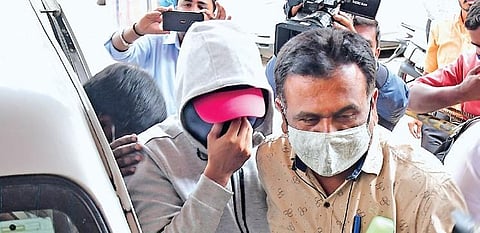 Aditya Alva (in grey jacket), who was absconding for the last four months, being escorted by CCB officers in Bengaluru on Tuesday | Shriram BN