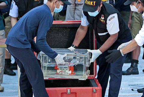Members of National Transportation Safety Committee place a box containing the flight data recorder of Sriwijaya Air flight SJ-182. (Photo | AP)