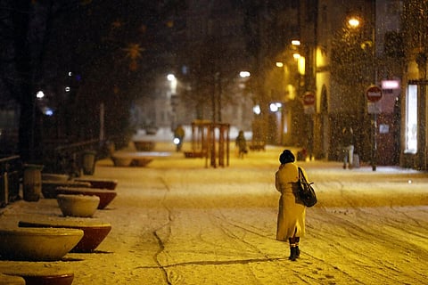 A woman walks during a snowfall after a curfew to prevent the spread of the coronavirus, in Strasbourg, eastern France. (Photo | AP)