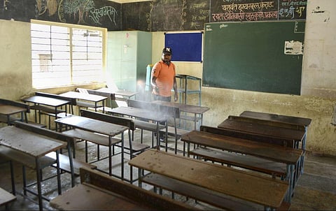 A municipal worker sanitises a classroom as per COVID-19 norms. (Photo | PTI)
