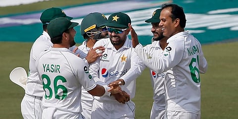 Pakistan's Nauman Ali (R) celebrates with teammates after taking the wicket of South Africa's batsman Dean Elgar at the National Stadium, in Karachi. (Photo | AP)
