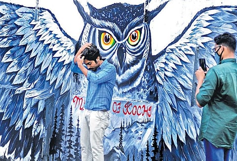 Tourists clicking photos infront the painted wall of an SBI branch in Fort Kochi.