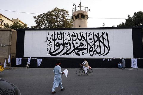 The Taliban flag is painted on a wall outside the American embassy compound in Kabul, Afghanistan. (File Photo | AP)