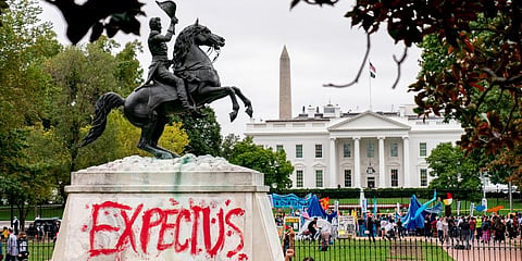 The words 'Expect Us' are spray painted on the base of the Andrew Jackson statue in Lafayette Park as Indigenous and environmental activists protest in front of the White House. (Photo | AP)