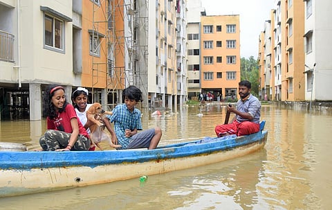 A man ferries three children and their pet dog from Thevarpazhanji at Poozhikunnu near Thrikkannapuram to a safer location. (Photo | B P Deepu, EPS)