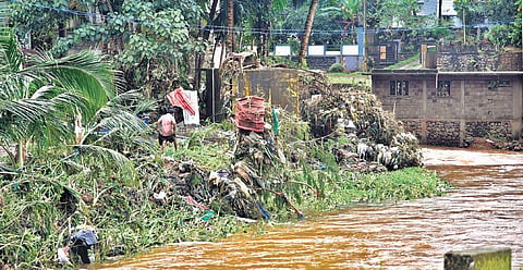 A man walks through a flood-ravaged section of the Manimala river bank at Mundakkayam in Kottayam on Monday | Albin Mathew
