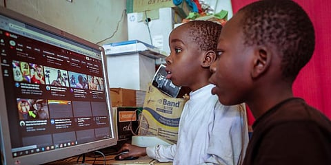 Two young boys use a computer at an internet cafe in the low-income Kibera neighborhood of Nairobi, Kenya. (Photo | AP)