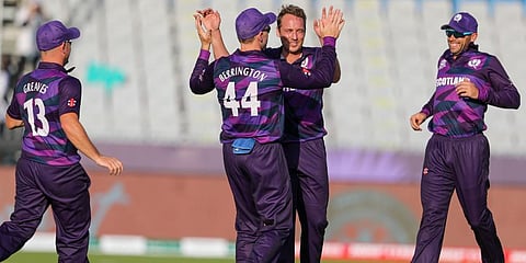 Scotland's Josh Davey, second right, celebrates with teammate Richie Berrington after taking the wicket Papua New Guinea's Simon Atai during the Twenty20 World Cup in Muscat. (Photo | AP)