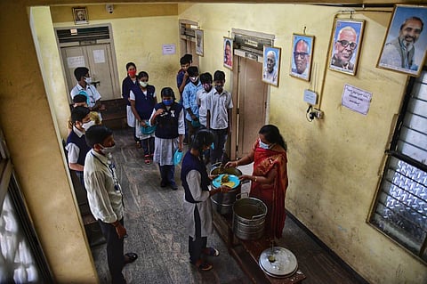 Children of a government school near Bannappa park standing in queue to get their meals on Thursday in Bengaluru. (Photo |Shriram BN, EPS)
