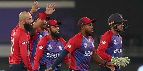England's Moeen Ali (L) celebrates with teammates after taking the wicket of West Indies' Lendl Simmons during the T20 World Cup match at the Dubai International Cricket Stadium in Dubai. (Photo | AP)