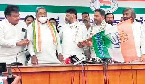 KPCC president DK Shivakumar hands over the Congress flag to party candidate  Ashok Managuli, as Leader of the Opposition Siddaramaiah, and senior leaders  MB Patil and Eshwar Khandre look on, in Sind