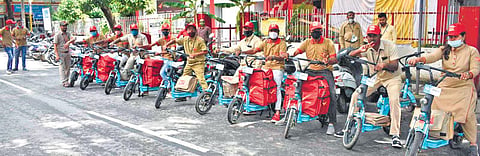 Postmen and postwomen astride their e-bikes outside the JP Nagar  sub post office in Bengaluru | Express