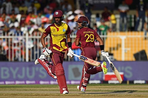 West Indies' Nicholas Pooran (R) and teammate Roston Chase run between the wickets during T20 WC match against West Indies at Sharjah Cricket Stadium, Sharjah on October 29, 2021. (Photo | AFP)