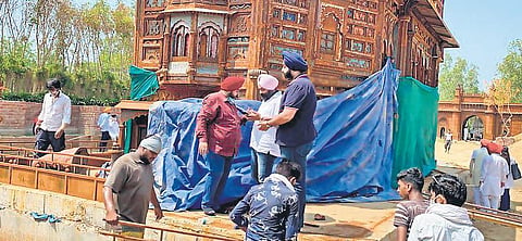 Gurudwara management committee members and municipal workers bring down  the replica of Golden Temple at Bharat Darshan Park in Punjabi Bagh. (File photo| EPS)
