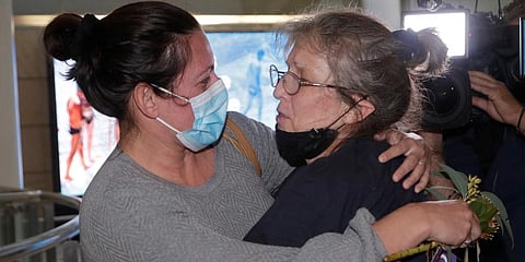 A woman (R) is embraced by. a loved-one after arriving on a flight from Los Angeles at Sydney Airport as Australia open its borders for the first time in 19 months in Sydney. (Photo | AP)
