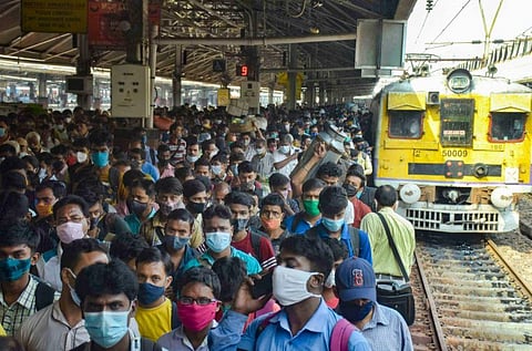 Passengers wait to board a local train after its services resumed, in Howrah. (Photo | PTI)