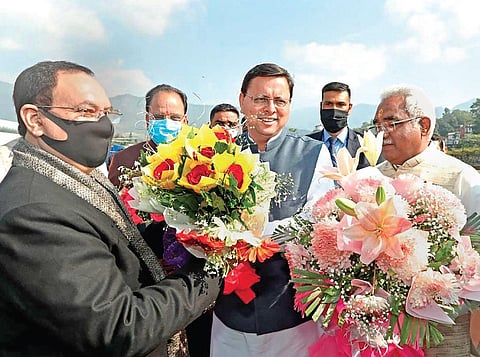 Uttarakhand Chief Minister Pushkar Singh Dhami welcomes BJP national  president J P Nadda on his arrival in Dehradun on Monday. (Photo | PTI)