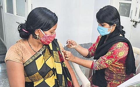 A health worker administers Covid vaccine to a woman in Bengaluru. (Photo | Shriram BN, EPS)