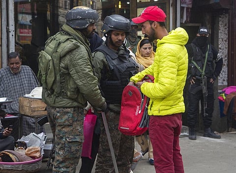 Indian paramilitary soldiers question a civilian during a surprise check operation in a busy market in Srinagar. (File photo | AP)