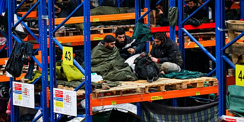 Migrants rest inside a logistics center at the checkpoint 'Kuznitsa' at the Belarus-Poland border near Grodno, Belarus. (Photo | AP)