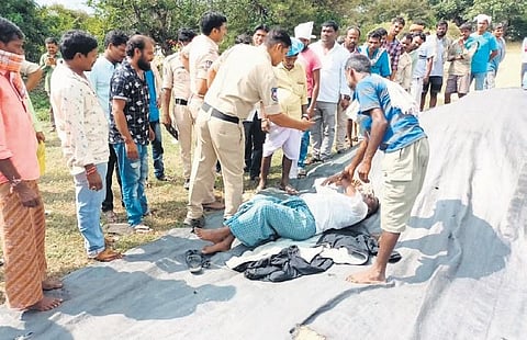 A police official clicks a picture of Beeraiah, 57, who died at an IKP centre  in Lingampet mandal, Kamareddy district, while guarding his huge heap of paddy