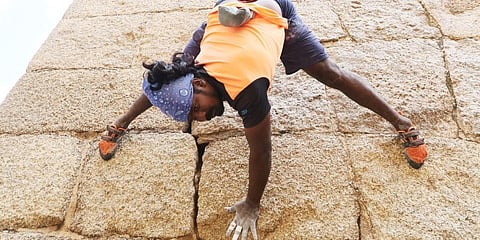 Jyothi Raj climbing fort wall at Chitradurga.
