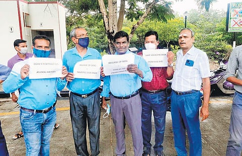 IIT Madras staff and faculty members hold placards and protest against the release of dogs from the enclosure  | Express