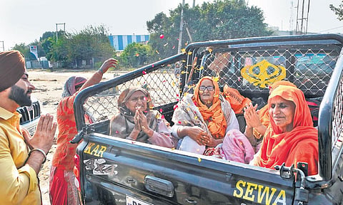 Farmers cheer as they leave the protest site at Singhu border in New Delhi on Saturday. (Photo | Shekhar Yadav)