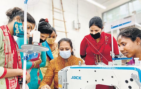 Women from Clothes Box Foundation creating blankets from fabric scraps.