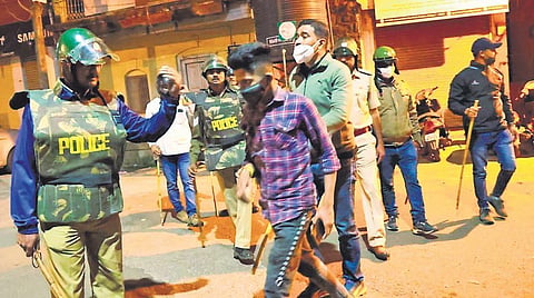 Police personnel detain a suspect for violence in Belagavi on Saturday | Express