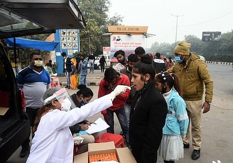 A Health worker takes swab sample for Covid19 test at akshardham metro station in New Delhi on Sunday. (Photo | EPS)