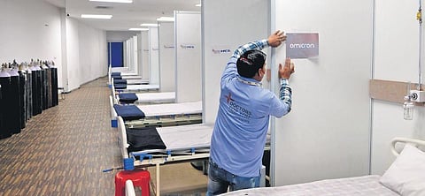 A worker demarcates the Omicron ward inside a dedicated Covid-19 facility at the Commonwealth Games Village in New Delhi | Shekhar yadav
