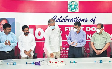 Health Minister T Harish Rao cuts a cake to celebrate Telangana’s milestone in becoming  the first large state to achieve 100 per cent  first-dose vaccination