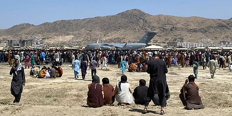 (Representational) Hundreds of people gather near a U.S. Air Force C-17 transport plane at the perimeter of the international airport in Kabul, Afghanistan. (File Photo | AP)