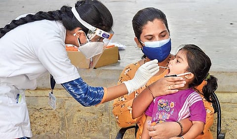 A child gives her throat samples for RTPCR test in Bengaluru. (File Photo  | Vinod kumar T)