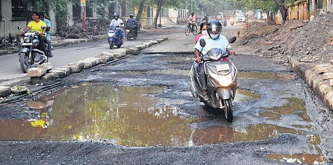 Commuters struggle on a pothole-filled Jothi Venkatachalam Road in Chennai on Saturday |  DEBADATTA MALLICK