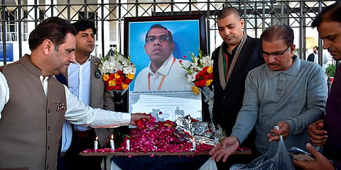 Businessmen put candles and rose petals next to the portrait of a Sri Lankan manager of a sports equipment factory in Sialkot. (Photo| AP)