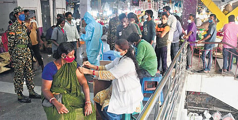 A health worker administers Covid-19 vaccine to a woman in KR Market, Bengaluru,   on Friday. (Photo |  Shriram BN/EPS)