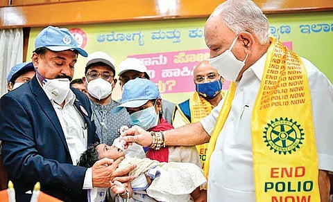 Chief Minister B S Yediyurappa administers polio vaccine to a baby at his  home office Krishna, in Bengaluru on Sunday