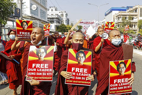 Buddhist monks display pictures of deposed leader Aung San Suu Kyi during a street march against the military coup in Mandalay, Myanmar. (Photo | AP)