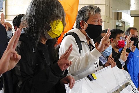 Hong Kong pro-democracy activists Lee Cheuk-yan wearing a black mask and Leung Kwok-hung wearing a yellow mask, shout slogans as they arrive at a court in Hong Kong. (Photo | AP)