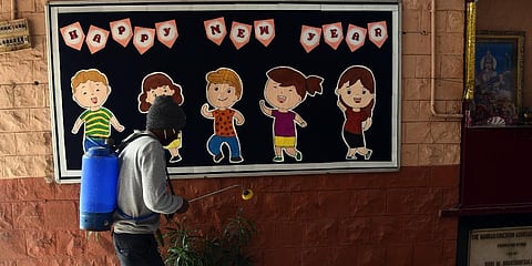 A worker seen spraying sanitizer at the school premises in New Delhi. (Photo | Parveen Negi, EPS)