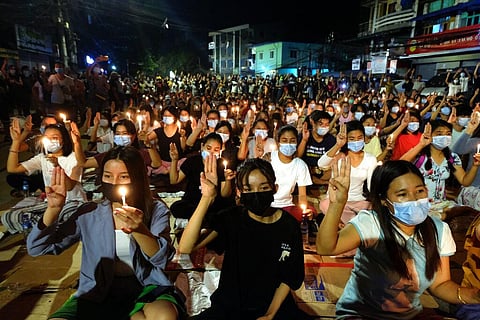 Anti-coup protesters flash the three-fingered salute during a candlelight night rally in Yangon, Myanmar. (Photo | AP)