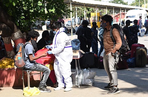 A health worker clad in a PPE suit collects swab samples from passengers at KSR Railway Station on Tuesday | Vinod Kumar T