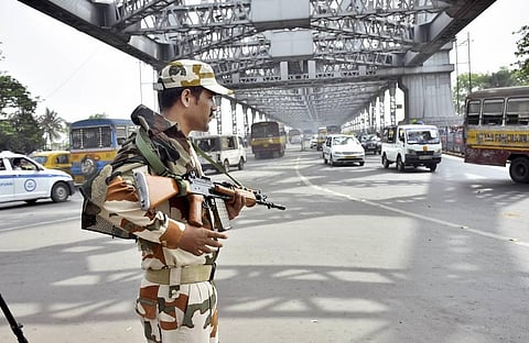 A security personnel stands guard on Howrah Bridge ahead of the West Bengal Assembly Polls. (Photo | PTI)